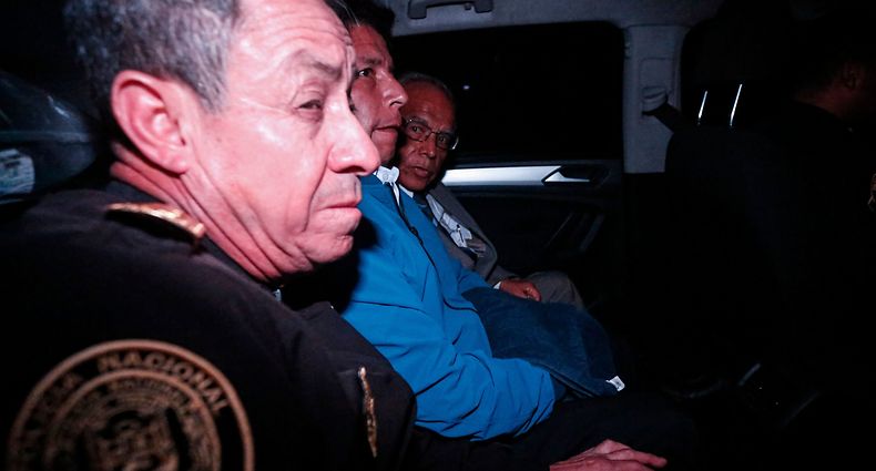 Peru's former President Pedro Castillo (C) is seen inside a police car as he leaves the Lima Prefecture, where he was under detention, in Lima, on December 7, 2022. - Peru's Pedro Castillo was impeached and replaced as president by his deputy on Wednesday in a dizzying series of events in the country that has long been prone to political upheaval. Dina Boluarte, a 60-year-old lawyer, was sworn in as Peru's first female president just hours after Castillo tried to wrest control of the legislature in a move criticised as an attempted coup. (Photo by Renato Pajuelo / AFP)