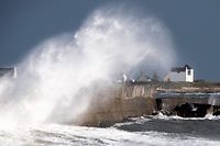 A big wave crashes on a pier in front of a house in Lesconil, western France, on December 28, 2020, as storm Bella caused torrential rain and heavy winds in much of France. (Photo by LOIC VENANCE / AFP)