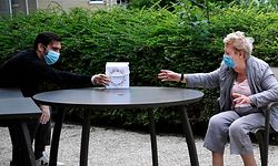 An elderly woman, resident of an EHPAD (Establishment for the Housing of Elderly Dependant People) receives a gift from her grandson on Mother's Day in Saint-Maur-des-Fosses, near Paris, on June 7, 2020 during the second phase of the easing of lockdown measures taken to curb the spread of the COVI-19 pandemic, caused by the novel coronavirus. (Photo by Anne-Christine POUJOULAT / AFP)