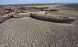 (FILES) In this file photo taken on October 18, 2018 young men sit in stationary engineless boats which lie idle at the dried inland Lake Chilwa's Chisi Island harbour in Zomba District, eastern Malawi. - Rising global temperature, rising sea levels, intensification of extreme events... The publication of the report of the Intergovernmental Panel on Climate Change (IPCC) is scheduled on August 9. (Photo by AMOS GUMULIRA / AFP)