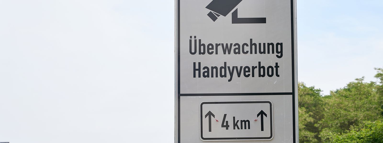 Ein Schild an der Autobahn A60 weist auf den Einsatz eines neuartigen Systems zur Feststellung von Handyverstößen am Steuer hin. Das von der niederländischen Polizei entwickelte System namens "Monocam" wird von der rheinland-pfälzischen Polizei getestet.
