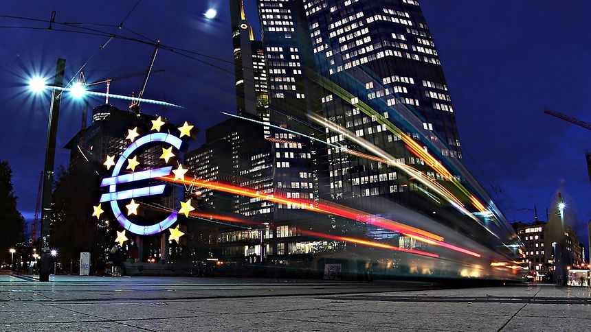 The giant Euro symbol stands illuminated outside the headquarters of the European Central Bank