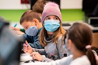 21.10.2020, Hessen, Frankfurt/Main: Mit Mundschutzmasken sitzen Schülerinnen und Schüler der fünften Klasse eines Gymnasiums in Frankfurt im Unterricht, ein Mädchen trägt eine Mütze. Neben dem obligatorischen Tragen von Masken gehört das regelmässige Lüften der Klassenräume zum Hygienekonzept an den hessischen Schulen. Foto: Boris Roessler/dpa +++ dpa-Bildfunk +++