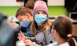 21.10.2020, Hessen, Frankfurt/Main: Mit Mundschutzmasken sitzen Schülerinnen und Schüler der fünften Klasse eines Gymnasiums in Frankfurt im Unterricht, ein Mädchen trägt eine Mütze. Neben dem obligatorischen Tragen von Masken gehört das regelmässige Lüften der Klassenräume zum Hygienekonzept an den hessischen Schulen. Foto: Boris Roessler/dpa +++ dpa-Bildfunk +++