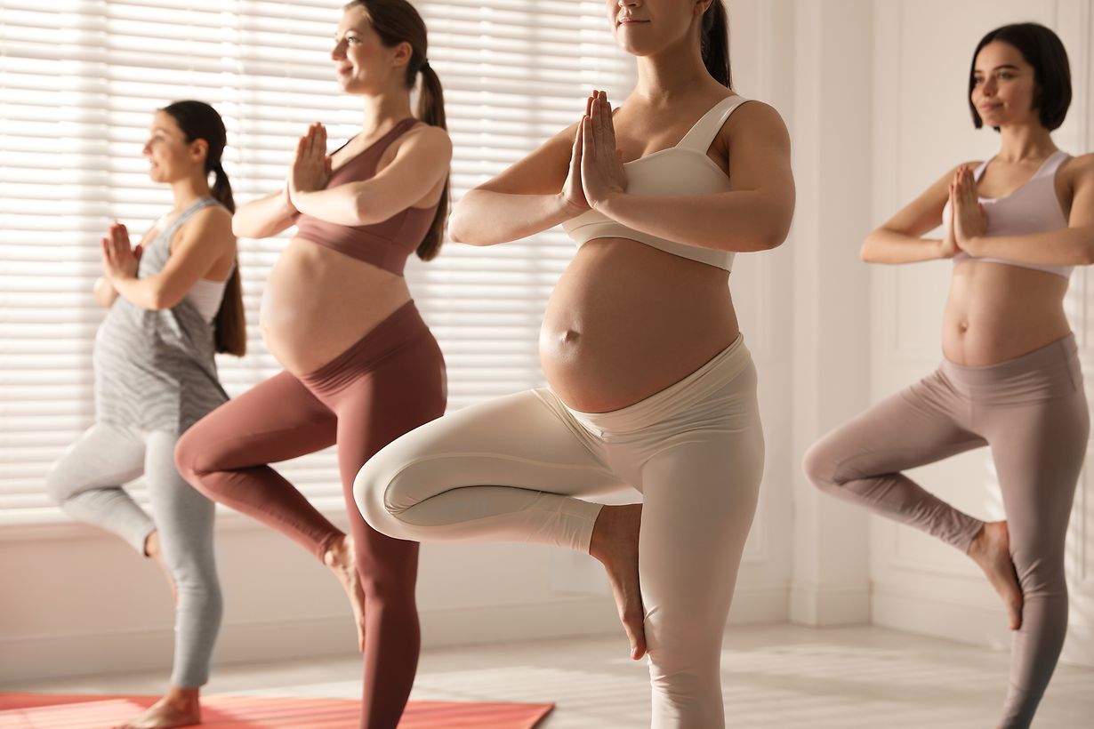 Group of pregnant women practicing yoga in gym, closeup