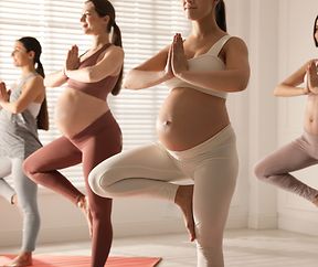 Group of pregnant women practicing yoga in gym, closeup