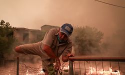 08.08.2021, Griechenland, Evia Island: Ein Mann rettet sich während der Löscharbeiten eines Waldbrandes im Dorf Pefki auf der Insel Euböa über einen Zaun. Die Lage wird immer bedrohlicher: Auf der griechischen Insel Euböa stehen auch am siebten Tag gewaltige Waldflächen in Flammen, die Brände breiten sich unkontrolliert aus. Foto: Eurokinissi/Eurokinissi via ZUMA Press Wire/dpa +++ dpa-Bildfunk +++