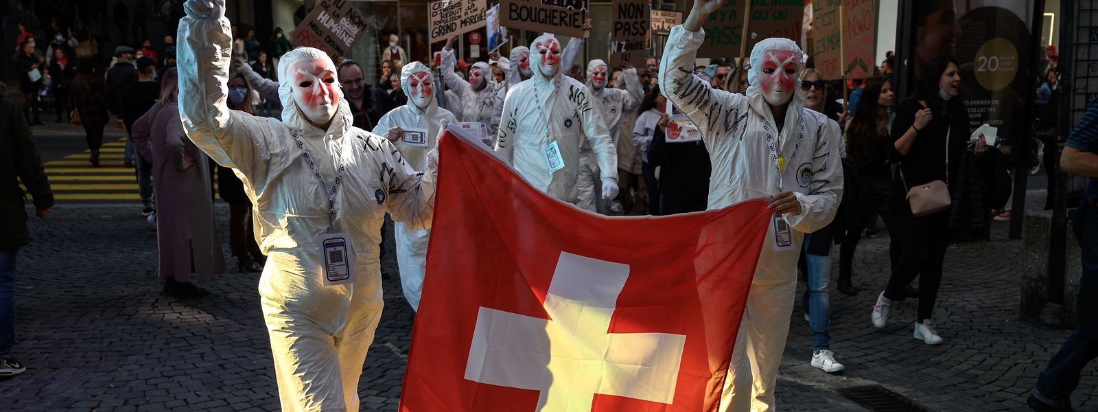 Auf diesem Foto  halten Demonstranten eine Schweizer Flagge während einer Kundgebung gegen die Corona-Maßnahmen in Lausanne hoch.