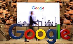 (FILES) In this file photo taken on January 22, 2019 a technician passes by a logo of US internet search giant Google during the opening day of a new Berlin office of Google in Berlin. - Google parent Alphabet reported a rare drop in revenue and profit on July 30, 2020, in a quarterly update that nonetheless topped market expectations. (Photo by Tobias SCHWARZ / AFP)