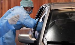 A medical staff takes samples to a driver at a "drive-through" testing facility for the novel coronavirus at the "Hopital de la Citadelle" hospital in Liege, on it's opening day on March 10, 2020. (Photo by ERIC LALMAND / BELGA / AFP) / Belgium OUT