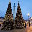 People stand near Christmas trees in front of the Vendome Column as part of Christmas holiday season illuminations at Place Vendome in Paris, France, December 11, 2016.   REUTERS/Charles Platiau