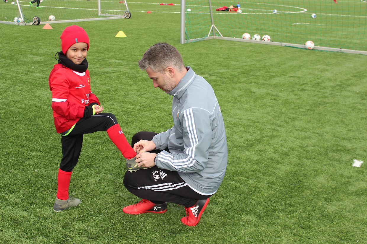 Os treinadores/ educadores ocupam-se dos jogadores desempenhando várias funções, até na de ajudar a dar os laços correctos as botas...