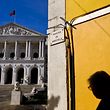 A woman passes infront of the Portuguese parliament in Lisbon on November 11, 2015 a day after the fall of the 11-day-old conservative minority government. President Anibal Cavaco Silva is set to decide whether to charge Socialist leader Antonio Costa with forming a new government in the face of concerns over whether the fragile leftist alliance can last.   AFP PHOTO / PATRICIA DE MELO MOREIRA