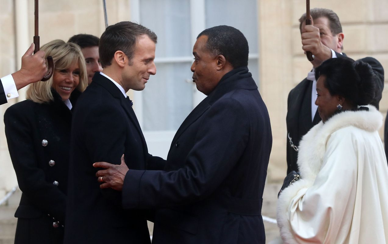 French President Emmanuel Macron (L) and his wife Brigitte Macron welcome Republic of the Congo's President Denis Sassou Nguesso and his wife Antoinette Sassou Nguesso at the Elysee Palace in Paris on November 11, 2018 ahead of the start of commemorations marking the 100th anniversary of the 11 November 1918 armistice, ending World War I. (Photo by Jacques Demarthon / AFP)