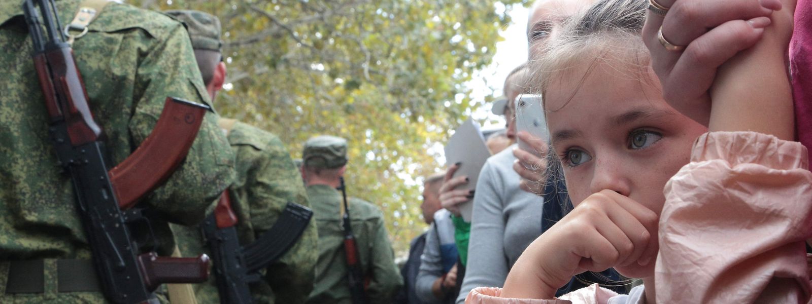 Russische Reservisten werden für den Ukraine-Krieg eingezogen. Daneben die sorgenvollen Blicke ihrer Verwandten.