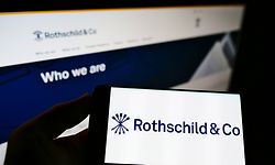 Person holding smartphone with logo of French financial services company Rothschild Co