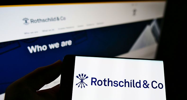 Person holding smartphone with logo of French financial services company Rothschild Co