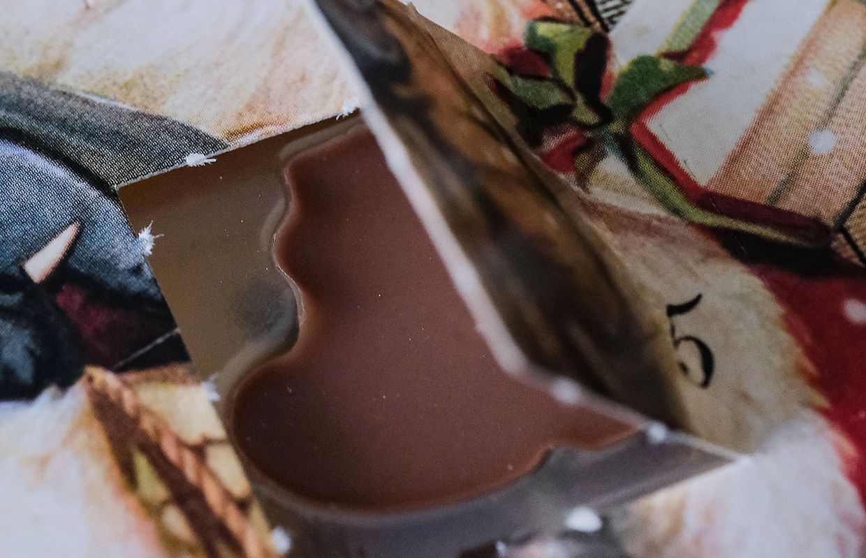 Ein Türchen an einem klassischen Adventskalender, der mit Schokolade bestückt ist.
