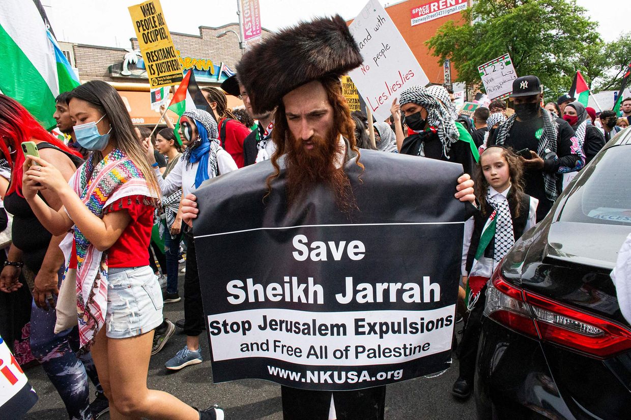 Um homem judeu anti-sionista veste um cartaz de apoio à Palestina em Queens, em Nova Iorque, a 22 de Maio de 2021. 