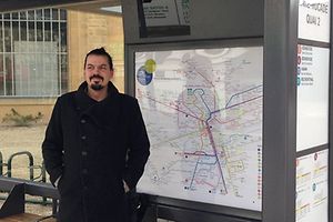 Jug Cerovic devant la carte des lignes de bus de Luxembourg, qu'il a lui-même dessinée.
