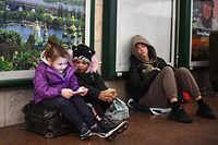Família espera na estação de Kiev, Ucrânia. 