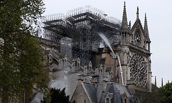 TOPSHOT - Firefighters spray water as they work to extinguish a fire at Notre-Dame Cathedral in Paris early on April 16, 2019. - A huge fire that devastated Notre-Dame Cathedral is "under control", the Paris fire brigade said early on April 16 after firefighters spent hours battling the flames. (Photo by Zakaria ABDELKAFI / AFP)