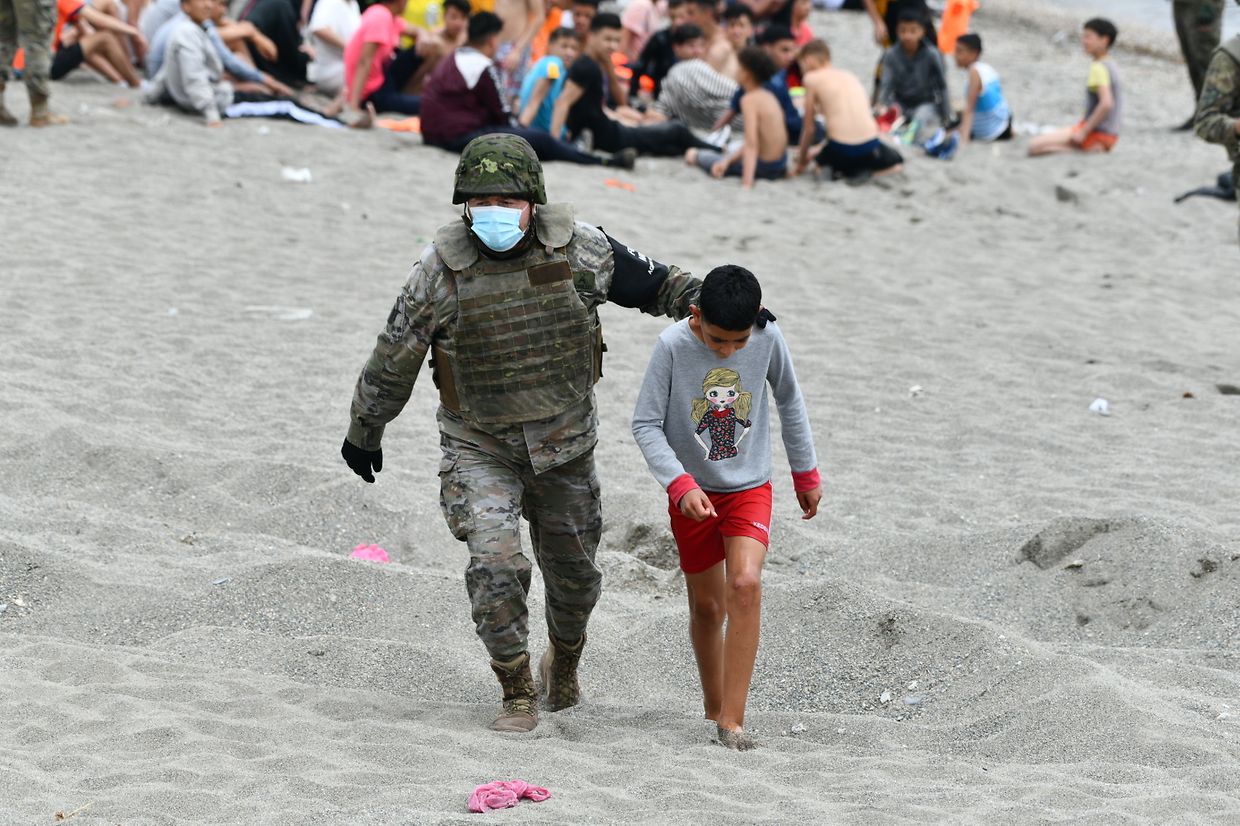 Ein spanischer Soldat begleitet ein Kind nach seiner Ankunft in Ceuta. Innerhalb von 36 Stunden gelangten rund 8000 Menschen in das kleine Gebiet im Nordwesten von Marokko. Die Zahl der wieder nach Marokko abgeschobenen Menschen erhöhte sich unterdessen auf circa 5600.