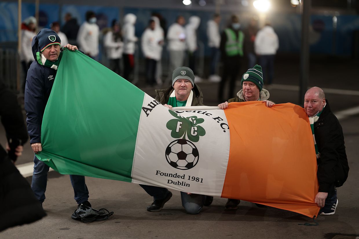Irish fans who traveled with them proudly present the flag of their country.