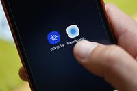 A man uses the Robert Koch Institute's coronavirus app 'Corona-Datenspende' (Corona Data Donation) on his smartphone in Dortmund, western Germany, on April 27, 2020 amid the novel coronavirus COVID-19 pandemic. - German Robert Koch Institute, responsible for disease control and prevention, developped an app to help to provide information and detect infections with the SARS-CoV-2 coronavirus which causes the Covid-19 disease. (Photo by Ina FASSBENDER / AFP)