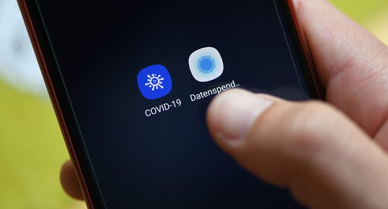A man uses the Robert Koch Institute's coronavirus app 'Corona-Datenspende' (Corona Data Donation) on his smartphone in Dortmund, western Germany, on April 27, 2020 amid the novel coronavirus COVID-19 pandemic. - German Robert Koch Institute, responsible for disease control and prevention, developped an app to help to provide information and detect infections with the SARS-CoV-2 coronavirus which causes the Covid-19 disease. (Photo by Ina FASSBENDER / AFP)