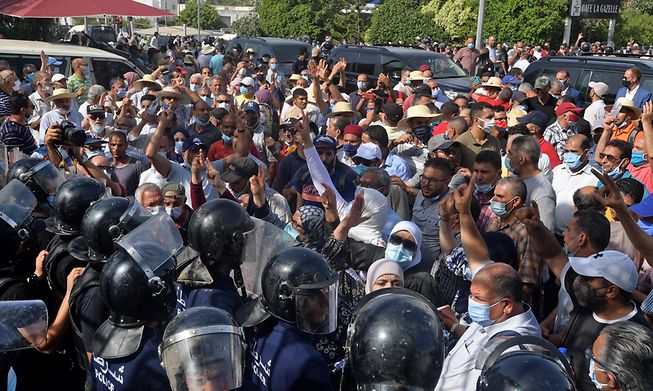 Tunisian security officers hold back protesters outside the parliament building in the capital Tunis on 26 July