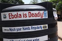 ARCHIV - ILLUSTRATION - 01.08.2015, Liberia, Monrovia: Liberianer gehen an einem Tank mit chloriertem Wasser vorbei, mit dem die Hände regelmäßig gewaschen werden sollen, um die Ausbreitung des Ebola Virus einzudämmen. Im Kongo versuchen die Behörden zusammen mit der Weltgesundheitsorganisation (WHO), einen neuen Ausbruch des gefürchteten Ebola-Virus einzudämmen. Zwei Fälle von Ebola seien in der Provinz Äquator im Nordwesten des Landes bestätigt worden, teilte das kongolesische Gesundheitsministerium mit. Foto: Ahmed Jallanzo/EPA/dpa +++ dpa-Bildfunk +++