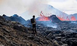A person looks on the scene of the newly erupted volcano taking place in Meradalir valley, near mount Fagradalsfjall, Iceland on August 4, 2022. - The eruption is some 40 kilometres (25 miles) from Reykjavik, near the site of the Mount Fagradalsfjall volcano that erupted for six months in March-September 2021, mesmerising tourists and spectators who flocked to the scene. (Photo by Jeremie RICHARD / AFP)