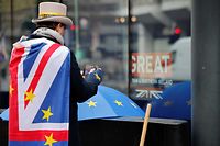 Anti-Brexiteer activist Steve Bray looks at his mobile phone as he protests outside a conference centre in central London on December 4, 2020, as talks continue on a trade deal between the EU and the UK. - With just a month until Britain's post-Brexit future begins and trade talks with the European Union still deadlocked, the UK government on Tuesday urged firms to prepare as it scrambles to finish essential infrastructure. (Photo by Tolga Akmen / AFP)