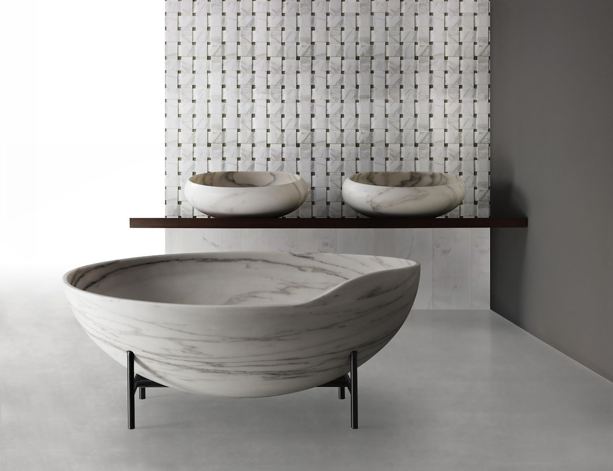 Enzo Berti hat für Kreoo eine fast zerbrechlich wirkende Badewanne entworfen. Sie wird aus einem einzelnen Marmorblock geschnitten und ruht in einem filigranen Eisengestell. 