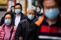 Pedestrians wear face masks in Hong Kong on February 3, 2020, as a preventative measure following a virus outbreak which began in the Chinese city of Wuhan. - Hundreds of Hong Kong medical workers walked off their jobs on February 3, demanding the city close its border with China to reduce the coronavirus spreading -- with frontline staff threatening to follow suit in the coming days. (Photo by Anthony WALLACE / AFP)