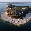 TOPSHOT - An aerial view taken on August 16, 2022 shows the peninsula of Sirmione on Lake Garda, northern Italy, as the lake's waters recede due to severe drought. (Photo by MIGUEL MEDINA / AFP)