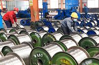 Workers move rolls of aluminum at a factory in Zouping in China's eastern Shandong province on April 7, 2018. China said on April 6 it is ready to pay