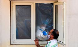 TOPSHOT - A medical worker collects a sample from a man for Rapid Antigen Test (RAT) for the Covid-19 coronavirus at an ayurvedic dispensary in a residential area in New Delhi on September 7, 2020. - India overtook Brazil on September 7 as the country with the second highest number of confirmed coronavirus cases, even as key metro train lines re-opened as part of efforts to boost the South Asian nation's battered economy. (Photo by Prakash SINGH / AFP)
