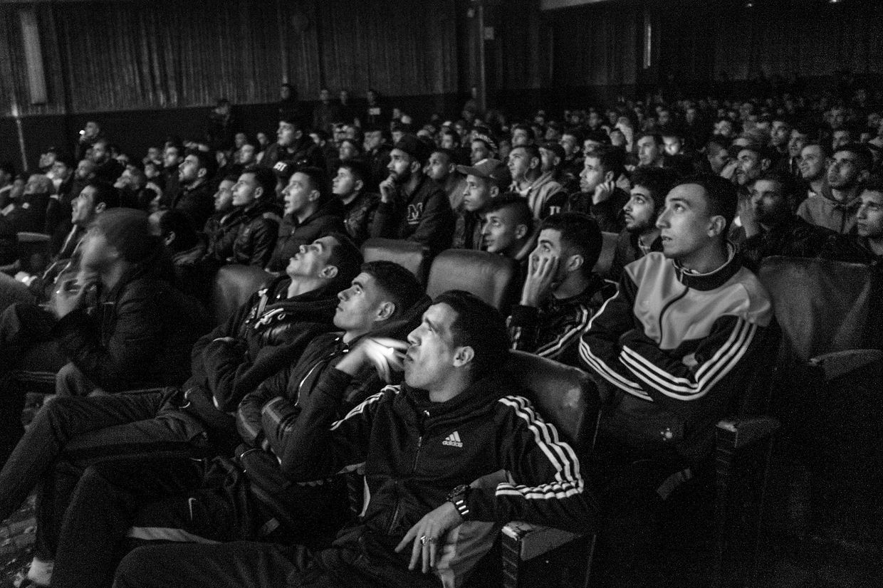 Les adolescents regardent un match de football diffusé au cinéma Olympia à Alger. Le cinéma diffuse les matches européens plusieurs fois par semaine. Photo de la série "Kho, l'origine d'une révolte".