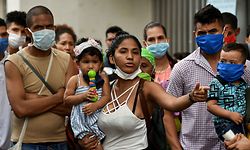Venezuelan migrants wait to be checked by health workers to rule out the novel coronavirus as part of their repatriation process in Cali, Colombia on April 13, 2020. - The Mayor of Cali, Jorge Ivan Ospina, announced Sunday a "humanitarian corridor" was started to repatriate Venezuelan migrants. (Photo by Luis ROBAYO / AFP)
