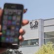(FILES) In this file photo taken on August 28, 2016, a woman uses her iPhone in front of the building housing the Israeli NSO group "Pegasus", in Herzliya, near Tel Aviv. - An Israeli firm accused of supplying spyware to governments has been linked to a list of 50,000 smartphone numbers, including those of activists, journalists, business executives and politicians around the world, according to reports Sunday. (Photo by JACK GUEZ / AFP)