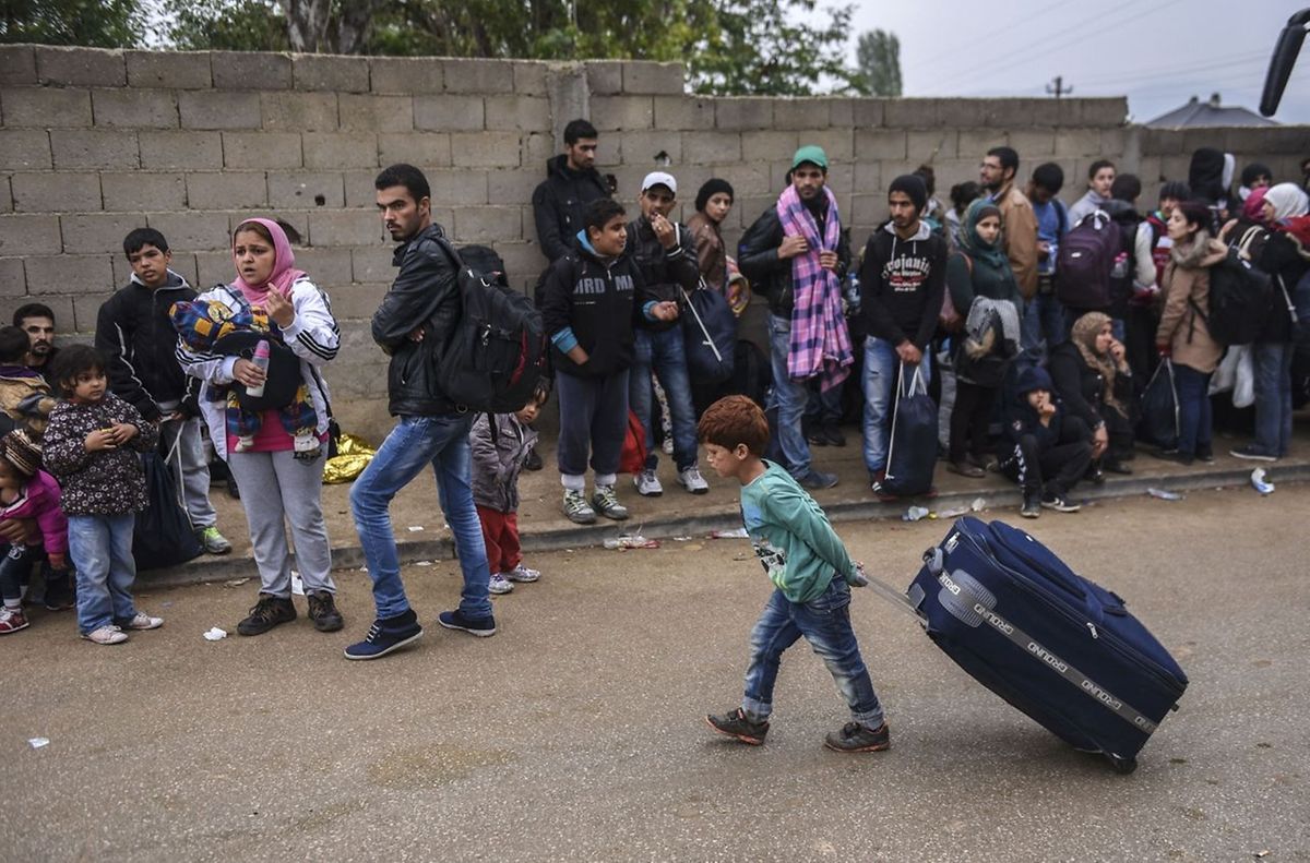 20 octobre 2015. Un enfant tire une lourde valise et se joint aux nombreux réfugiés qui attendent de passer la frontière entre Macédoine et Serbie.