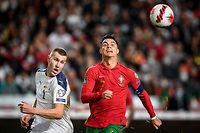 TOPSHOT - Serbia's defender Strahinja Pavlovic (L) fights for the ball with Portugal's forward Cristiano Ronaldo during the FIFA World Cup Qatar 2022 qualification group A football match between Portugal and Serbia, at the Luz stadium in Lisbon, on November 14, 2021. (Photo by PATRICIA DE MELO MOREIRA / AFP)