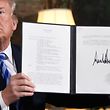 US President Donald Trump signs a document reinstating sanctions against Iran after announcing the US withdrawal from the Iran Nuclear deal, in the Diplomatic Reception Room at the White House in Washington, DC, on May 8, 2018. / AFP PHOTO / Saul LOEB / ALTERNATIVE CROP 