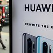 (FILES) In this file photo taken on April 29, 2019 A pedestrian walks past a Huawei product stand at an EE telecommunications shop in central London on April 29, 2019. - Britain is expected to announce next week whether to allow China's Huawei to develop its 5G network, an official said on January 24, 2020, indicating it will agree to limited access despite intense opposition from Washington. (Photo by Tolga Akmen / AFP)