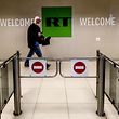 (FILES) This file photo taken on June 8, 2018 shows a man as he walks past a control post of the Russia Today (RT) TV company in Moscow. - EU to ban Russian state media RT and Sputnik announced European Commission President Ursula von der Leyen on February 27 , 2022. (Photo by Yuri KADOBNOV / AFP)