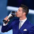 Real Madrid and Portugal's forward Cristiano Ronaldo kisses his trophy after winning the The Best FIFA Menís Player of 2016 Award next to FIFA president Gianni Infantino during The Best FIFA Football Awards ceremony, on January 9, 2017 in Zurich. / AFP PHOTO / Fabrice COFFRINI