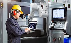 Maintenance engineer using laptop computer control automatic robotic hand with CNC machine in smart factory, Industry 4.0 concept - Image