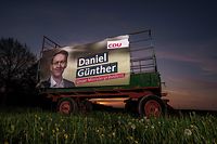 An election bilboard of Daniel Guenther (CDU) for the upcoming state election is on display parked in a field in Altenholz, Schleswig-Holstein, ahead of the weekend's election. (Photo by Axel Heimken / AFP)